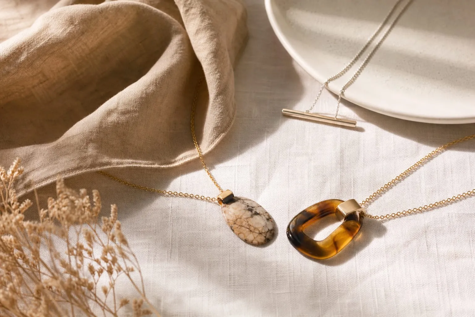 Chaînes dorées, pendentifs minéraux et jeux de longueurs superposées.